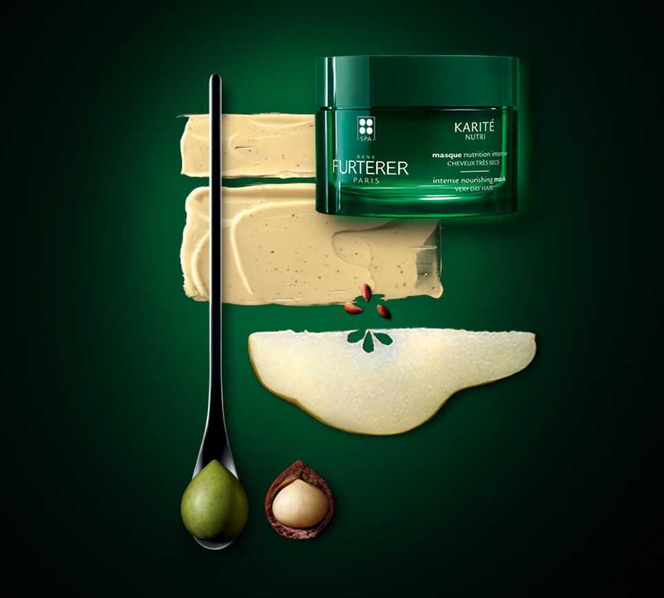 Hair mask jar with cream swatches, pear slice, spoon, and karité nut on green background.